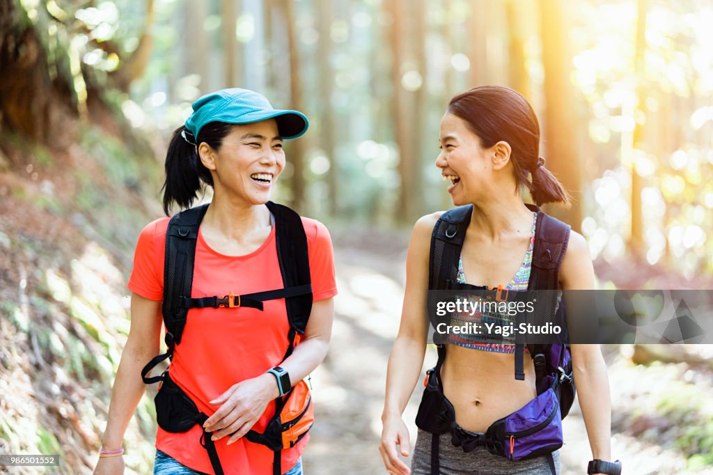 Two female trail runners running on a mountain path