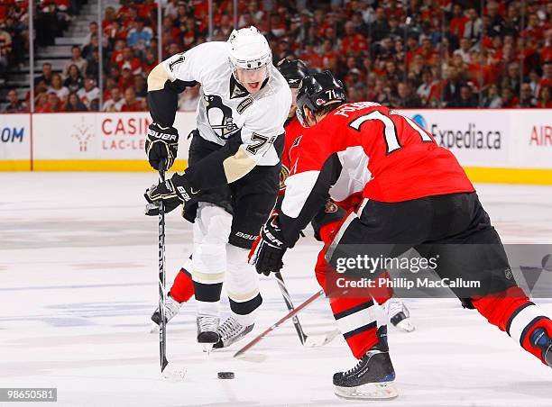 Evgeni Malkin of the Pittsburgh Penguins carries the puck up ice while being closely watched by Nick Foligno of the Ottawa Senators during Game 6 of...