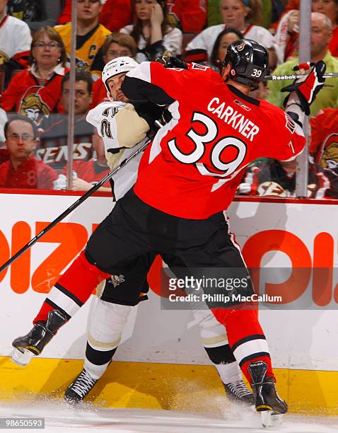 Matt Carkner of the Ottawa Senators throws a bodycheck on Craig Adams of the Pittsburgh Penguins during Game 6 of the Eastern Conference Quaterfinals...