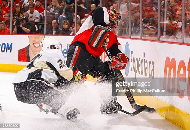 Matt Cooke of the Pittsburgh Penguins tries to slash the puck away from Pascal Leclaire of the Ottawa Senators in behind the net during Game 6 of the...
