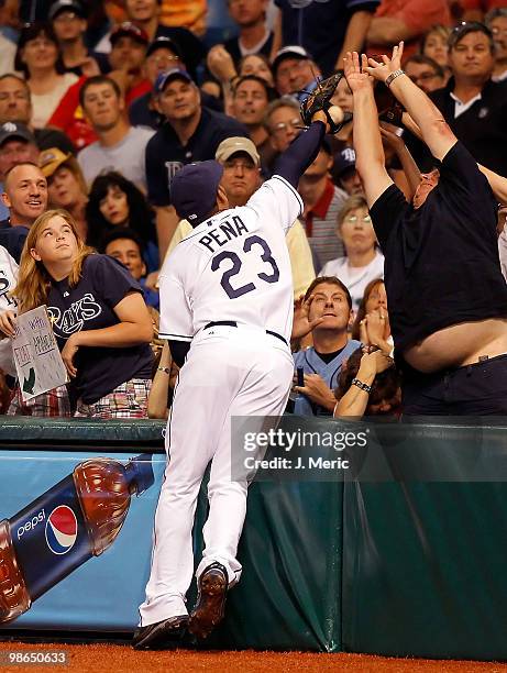 First baseman Carlos Pena of the Tampa Bay Rays goes into the crowd for a foul ball against the Toronto Blue Jays during the game at Tropicana Field...