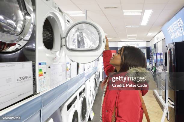 young woman in shop looking at kitchen appliances - cade stock-fotos und bilder