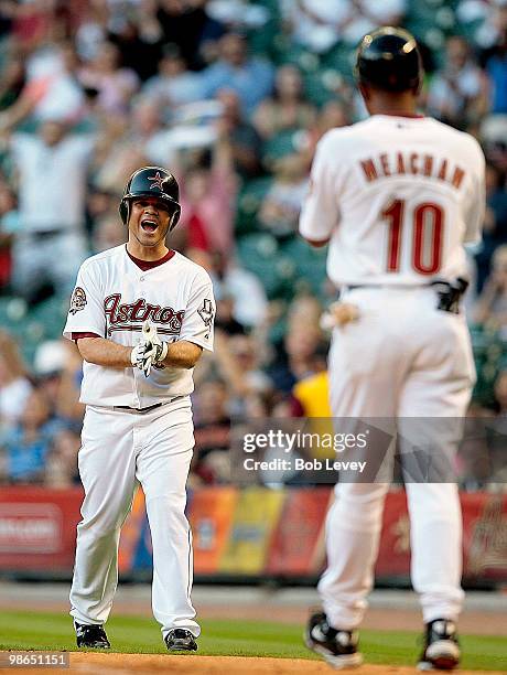 Pitcher Wandy Rodriguez of the Houston Astros reacts to first base coach Bobby Meacham after getting on base on a throwing error in the fourth inning...