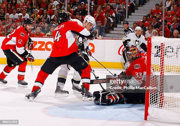 Pascal Leclaire of the Ottawa Senators makes a pad save down low while teammate Chris Phillips tries to tie up Alexei Ponikarovsky of the Pittsburgh...