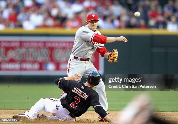 Infielder Chase Utley of the Philadelphia Phillies throws over the sliding Kelly Johnson of the Arizona Diamondbacks attempting a double play during...