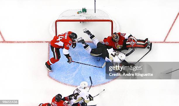 Sidney Crosby of the Pittsburgh Penguins dives across the crease for the puck as Anton Volchenkov and Pascal Leclaire stand their ground in Game Six...