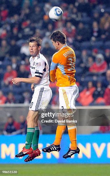 Brian McBride of the Chicago Fire heads the ball as he is defended by Bobby Boswell of the Houston Dynamo in an MLS match on April 24, 2010 at Toyota...