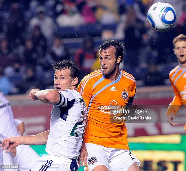 Brian McBride of the Chicago Fire heads the ball as he is defended by Eddie Robinson of the Houston Dynamo in an MLS match on April 24, 2010 at...