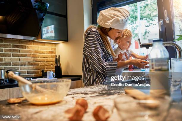 mother and her baby having fun cooking together - clean kitchen stock pictures, royalty-free photos & images