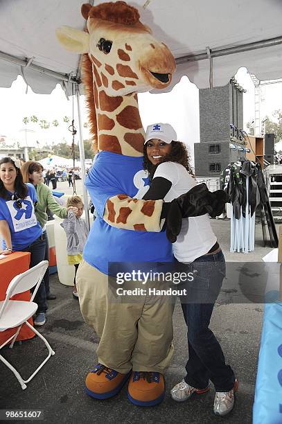 In this handout photo provided by Autism Speaks, Actress Holly Robinson Peete poses together with Geoffrey the Giraffe at the Walk Now for Autism...