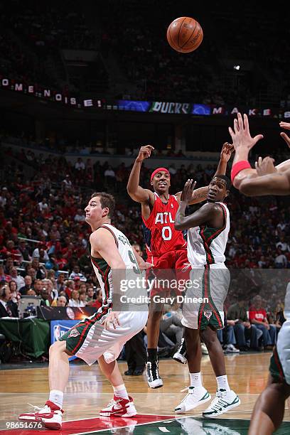 Jeff Teague of the Atlanta Hawks passes against Primoz Brezec and Royal Ivey of the Milwaukeee Bucks in Game Three of the Eastern Conference...