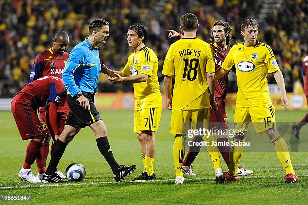 Forward Guillermo Barros Schelotto of the Columbus Crew and midfielder Kyle Beckerman of Real Salt Lake attempt to plead their cases with the referee...