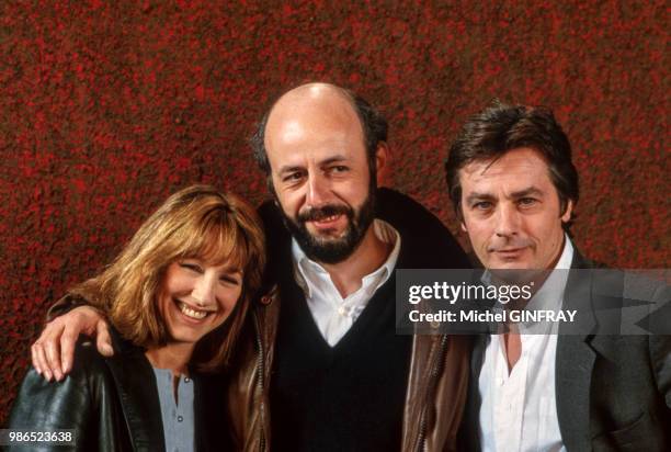 Portrait de Nathalie Baye, Alain Delon et le réalisateur Bertrand Blier posent pour le film 'Notre Histoire' en 1984, Paris, France.