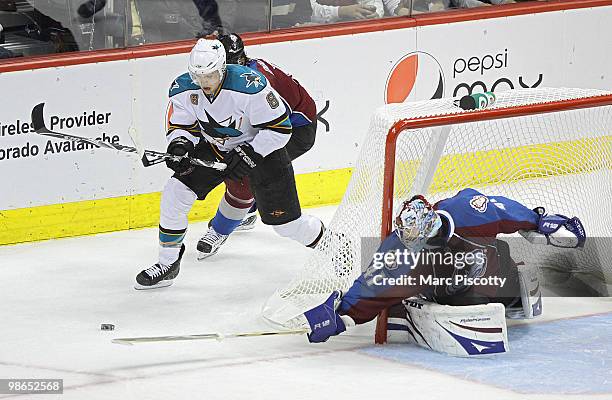 Goaltender Craig Anderson of the Colorado Avalanche tries to poke check the puck away from Joe Pavelski of the San Jose Sharks as Anderson's teammate...