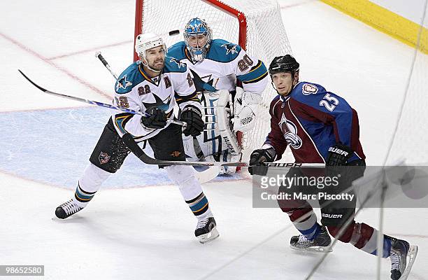 Chris Stewart of the Colorado Avalanche and Dan Boyle of the San Jose Sharks keep a close eye on an airborne puck in front of San Jose Sharks...