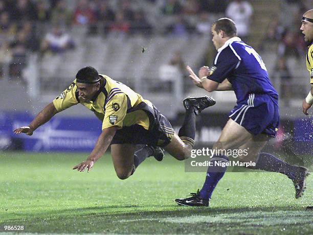 Jerry Collins of the Hurricanes goes flying as he off loads the ball chased by Craig Innes of the Blues during the Super 12 match between the Blues...