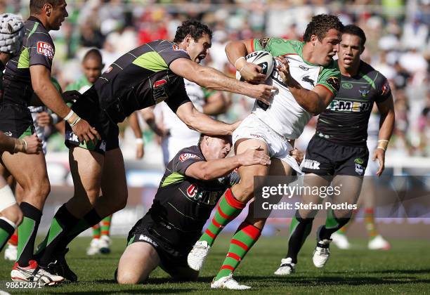 Sam Burgess of the Rabbitohs is tackled during the round seven NRL match between the Canberra Raiders and the South Sydney Rabbitohs at Canberra...