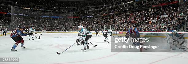Chris Stewart of the Colorado Avalanche takes a shot on goalie Evgeni Nabokov of the San Jose Sharks as Marc-Edouard Vlasic of the Sharks defends and...