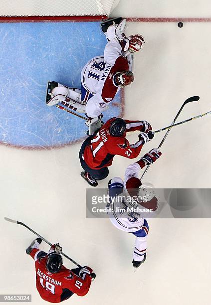 Brooks Laich of the Washington Capitals skates for the puck against Jaroslav Halak and Hal Gill of the Montreal Canadiens in Game Five of the Eastern...