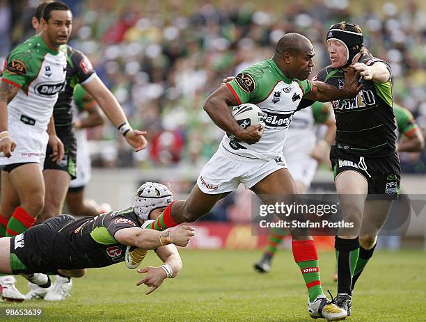 Rhys Wesser of the Rabbitohs fends off a tackle by Alan Tongue of the Raiders during the round seven NRL match between the Canberra Raiders and the...