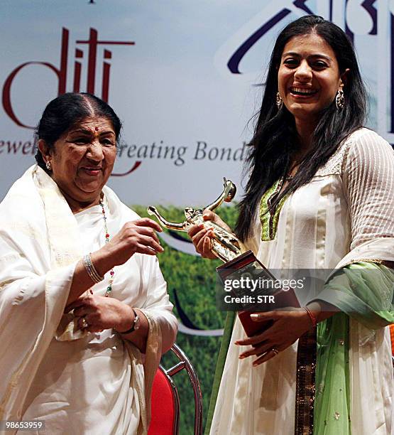 Indian Bollywood Hindi and Marathi classical singer Lata Mangeshkar receives the "Pandit Dinanath Mangeshkar Purashkar" award from actress Kajol...