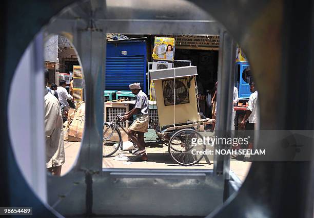 An Indian worker transports an air cooler to a buyer's residence on his bicycle cart in Hyderabad on April 25, 2010. Air coolers are in high demand...