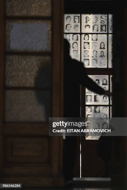 Man enters a room with portraits of people who dissapeared during the 1976-1983 dictatorship at the former Navy School -which was used as clandestine...