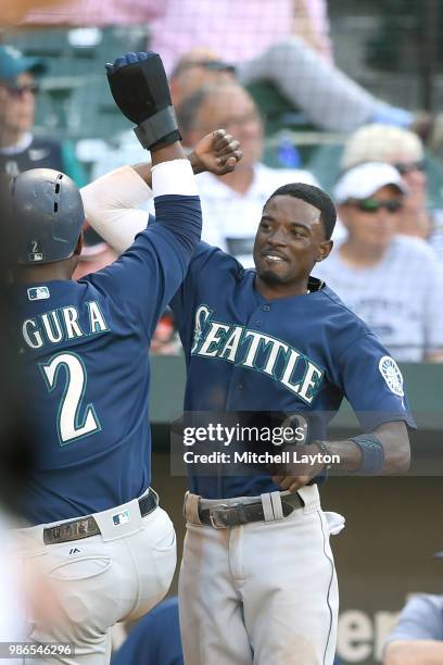 Dee Gordon of the Seattle Mariners celebrates with Jean Segura after scoreing on a Nelson Crus , hit in the tenth inning during a baseball game...