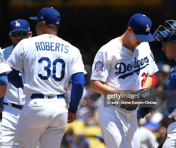 Walker Buehler of the Los Angeles Dodgers shows his frustration as he is pulled from the game by manager Dave Roberts after allowing the Chicago Cubs...