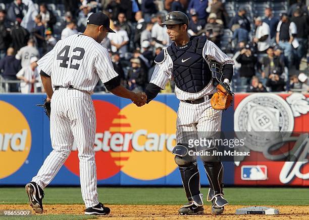 Jorge Posada and Mariano Rivera of the New York Yankees celebrate against the Los Angeles Angels of Anaheim during the Yankees home opener at Yankee...