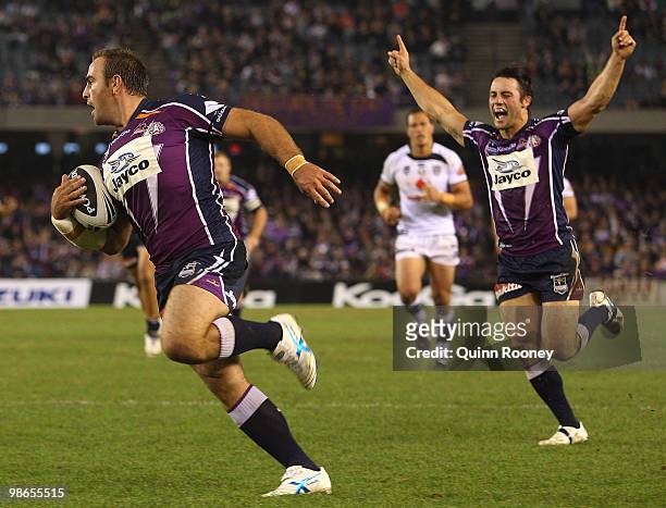Cooper Cronk celebrates as Ryan Tandy of the Storm scores a try during the round seven NRL match between the Melbourne Storm and the Warriors at...