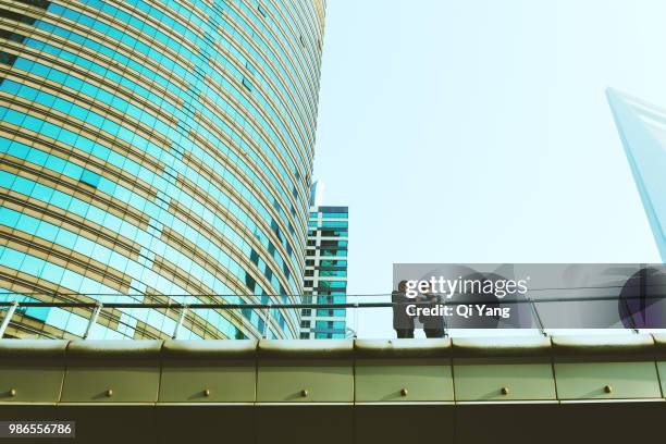 two businessmen standing on bridge and talking - qi yang stock pictures, royalty-free photos & images