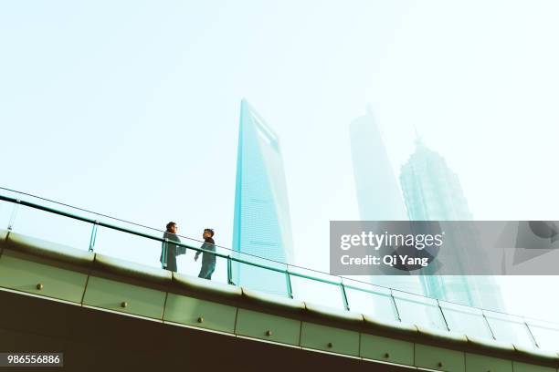 two businessmen standing on bridge and talking - shanghai city life stock pictures, royalty-free photos & images