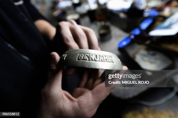 Craftman shows an engraved gold and silver ferrule for a mate, at the workshop of traditional handmade silverware store "Bresciani" in Montevideo on...