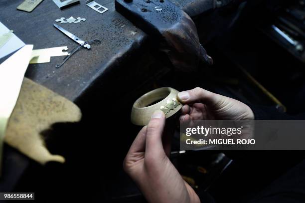 Craftman works on a gold and silver ferrule for a mate at the workshop of traditional handmade silverware store "Bresciani" in Montevideo on June 27,...