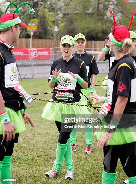 Princess Beatrice of York wears a green tutu and a 'Beatrice' baseball cap as she warms up prior to running the Virgin London Marathon in the...