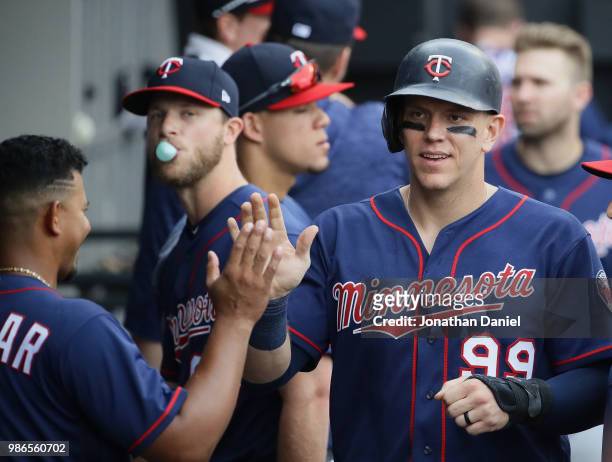Logan Morrison of the Minnesota Twins is congratulated in the dugout after scoring the game-winning run in the 13th inning against the Chicago White...