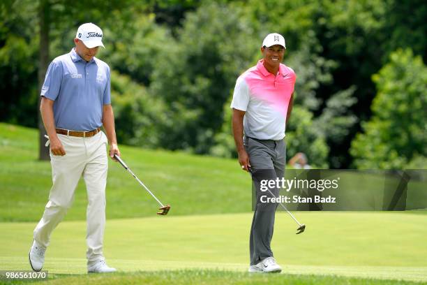 Bill Haas and Tiger Woods approaches the first green during the first round of the Quicken Loans National at TPC Potomac at Avenel Farm on June 28,...