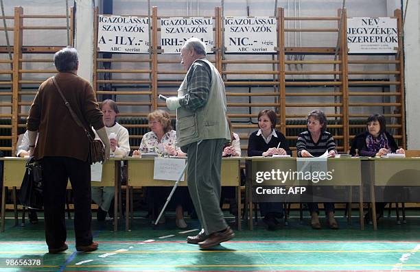 Locals receive their ballot-papers at the 93rd polling station of Budapest on April 25, 2010 during the second round of the general election. A...