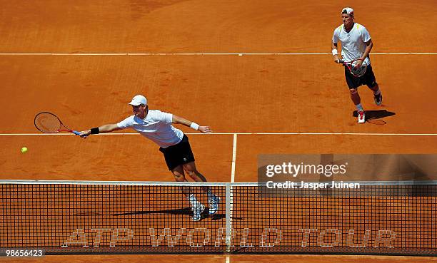 Mark Knowles of the Bahamas stretches to play a backhand flanked by his doubles partner Lleyton Hewitt of Australia during the the final doubles...