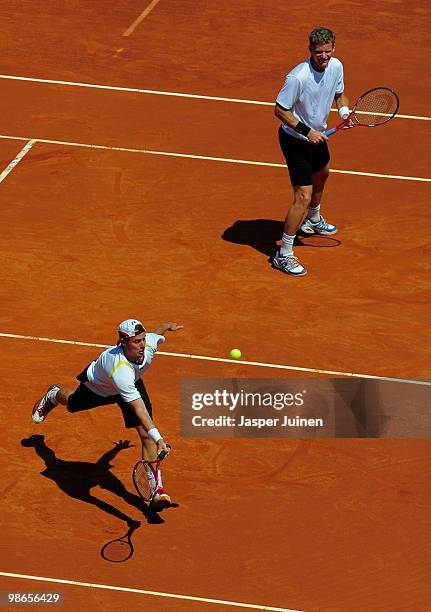 Lleyton Hewitt of Australia jumps to play a backhand flanked by his doubles partner Mark Knowles of the Bahamas during the final doubles match...