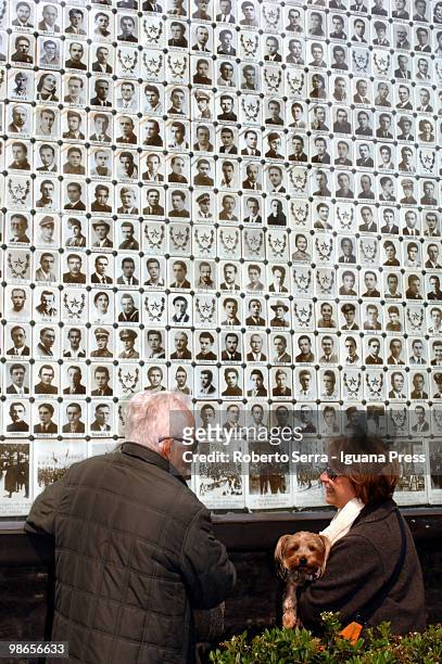 Man and a woman look at pictures of Italian insurgents killed during World War II on the wall of the Resistenza's shrine at Neptune square during the...