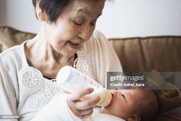 grandmother taking care of baby girl - grandma and baby stock pictures, royalty-free photos & images