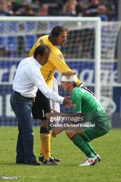 Head coach Jos Luhukay and Simon Jentzsch comfort Jonas de Roeck of Augsburg after the 1-1 draw of the Second Bundesliga match between FSV Frankfurt...