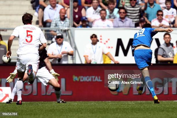 Vedad Ibisevic of Hoffenheim scores his team's first goal against Joris Mathijsen and goalkeeper Frank Rost of Hamburg during the Bundesliga match...