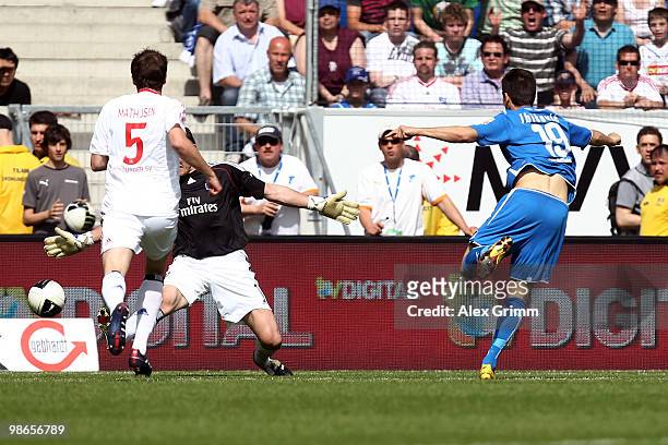 Vedad Ibisevic of Hoffenheim scores his team's first goal against Joris Mathijsen and goalkeeper Frank Rost of Hamburg during the Bundesliga match...