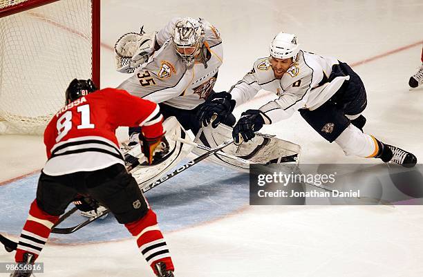 Marian Hossa of the Chicago Blackhawks scores the game-winning goal in overtime as Pekka Rinne and Shea Weber of the Nashville Predators dive to try...