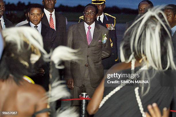 Zimbabwean President Robert Mugabe looks at traditional dancers upon his arrival 28 march 2007 in Dar es Salaam on the eve of the summit of southern...