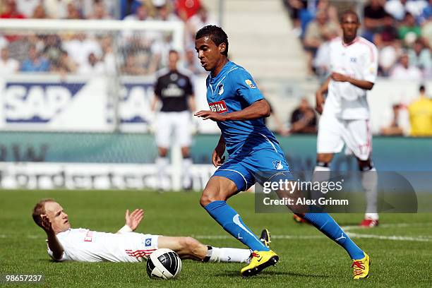 Luiz Gustavo of Hoffenheim runs with the ball as David Jarolim and Jerome Boateng of Hamburg react during the Bundesliga match between 1899...