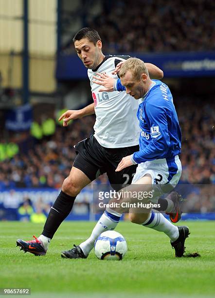 Tony Hibbert of Everton and Clint Dempsey of Fulham battle for the ball during the Barclays Premier League match between Everton and Fulham at...